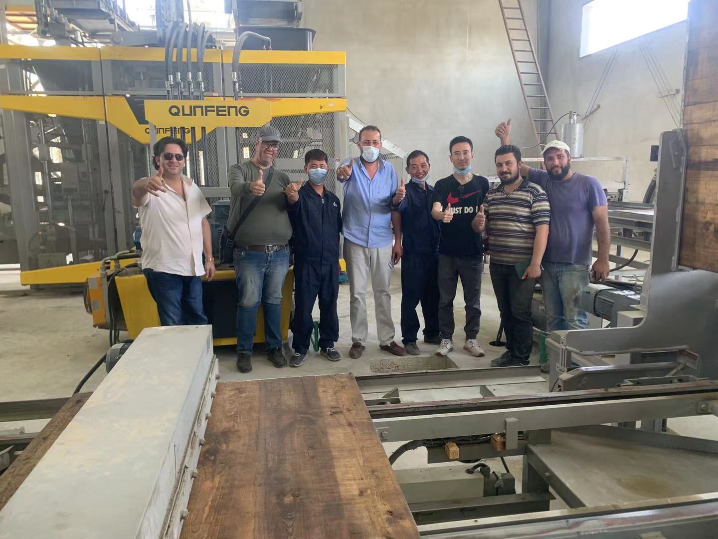 A photo of Qunfeng technical engineers with a customer; Qunfeng Machinery holds significant influence in the Middle East. Hình ảnh kỹ sư kỹ thuật Qunfeng với khách hàng; Qunfeng Machinery có ảnh hưởng đáng kể ở Trung Đông.