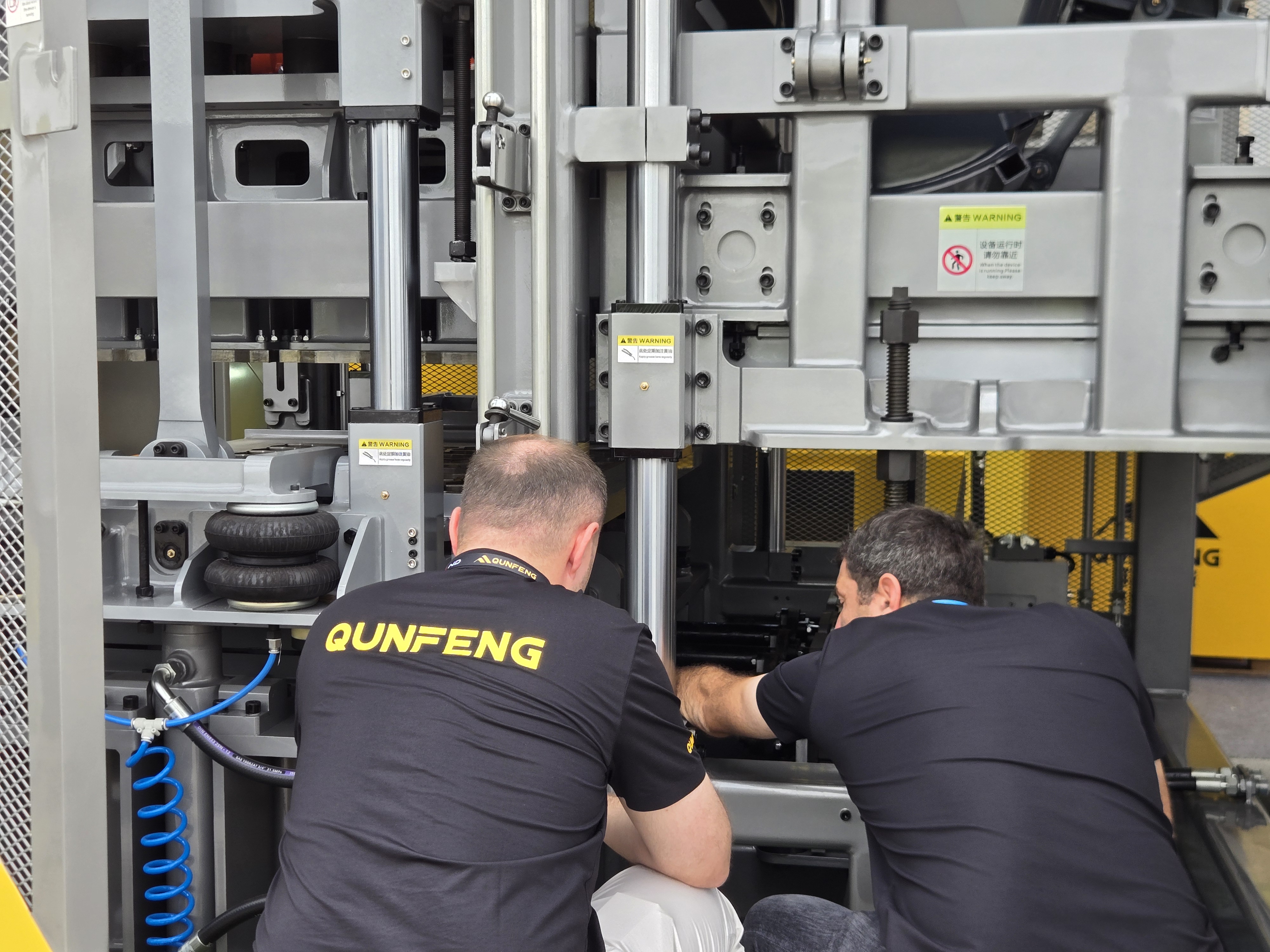 A Russian client carefully examines the details of Qunfeng Machinery equipment. Một khách hàng Nga kiểm tra cẩn thận các chi tiết của thiết bị Máy móc Qunfeng.